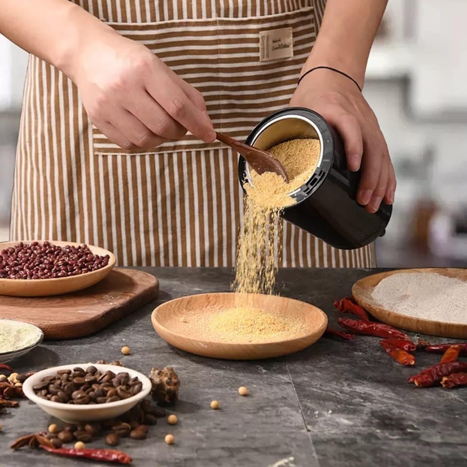 LLady removing coffe poweder from Portablle Coffee and Spice Grinder